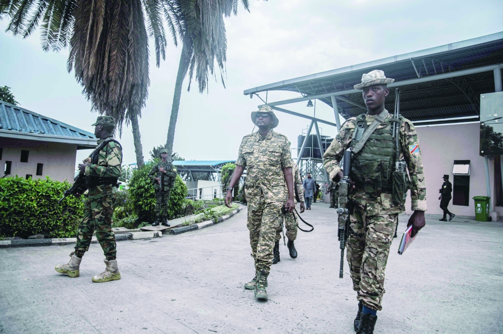 An M23 officer inspects the convoy repatriating soldiers at the main border crossing between DR Congo and Rwanda in Goma. — AFP