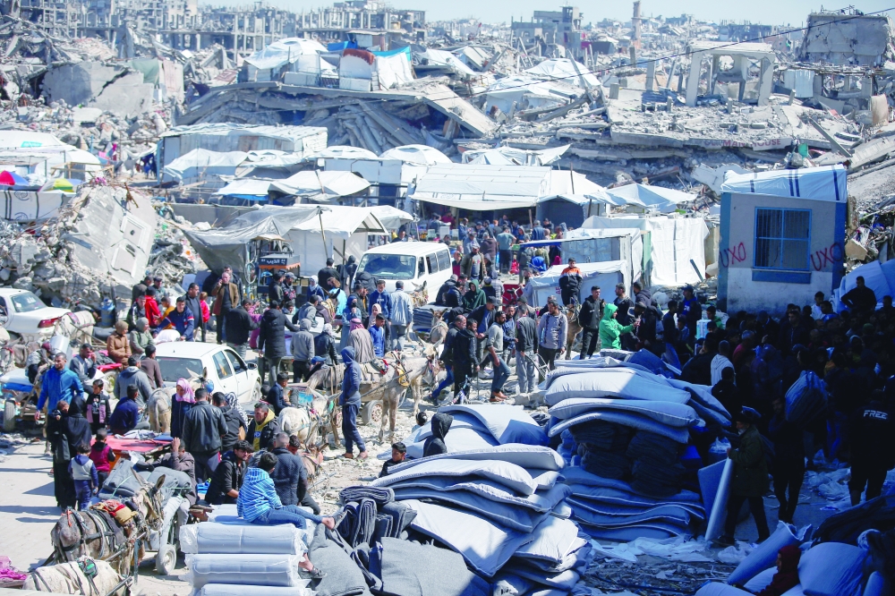 Palestinians gather to receive aid provided by UNRWA outside a distribution centre, at Jabalia refugee camp. — Reuters
