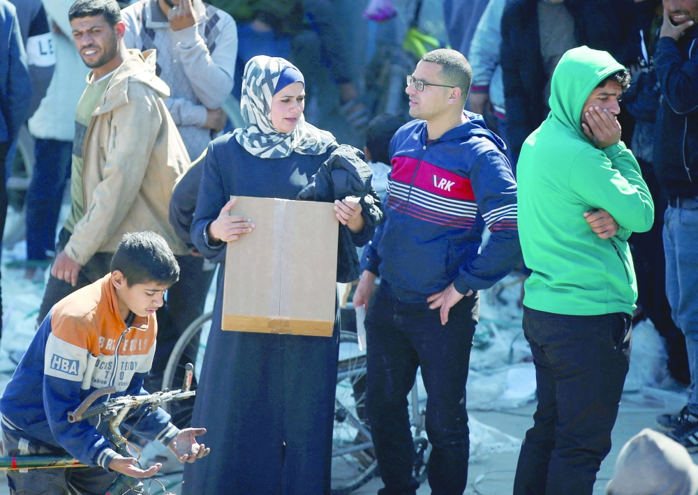 Palestinians gather to receive aid provided by UNRWA including food supplies outside a distribution centre at Jabalia refugee camp in northern Gaza Strip on Sunday. — Reuters