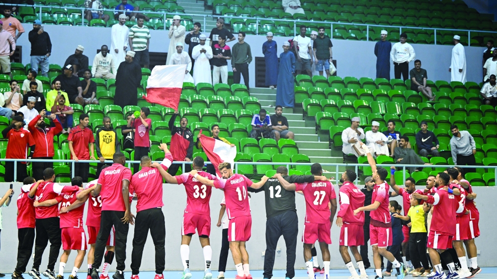 Oman Club players celebrate after winning the Oman Handball League title.