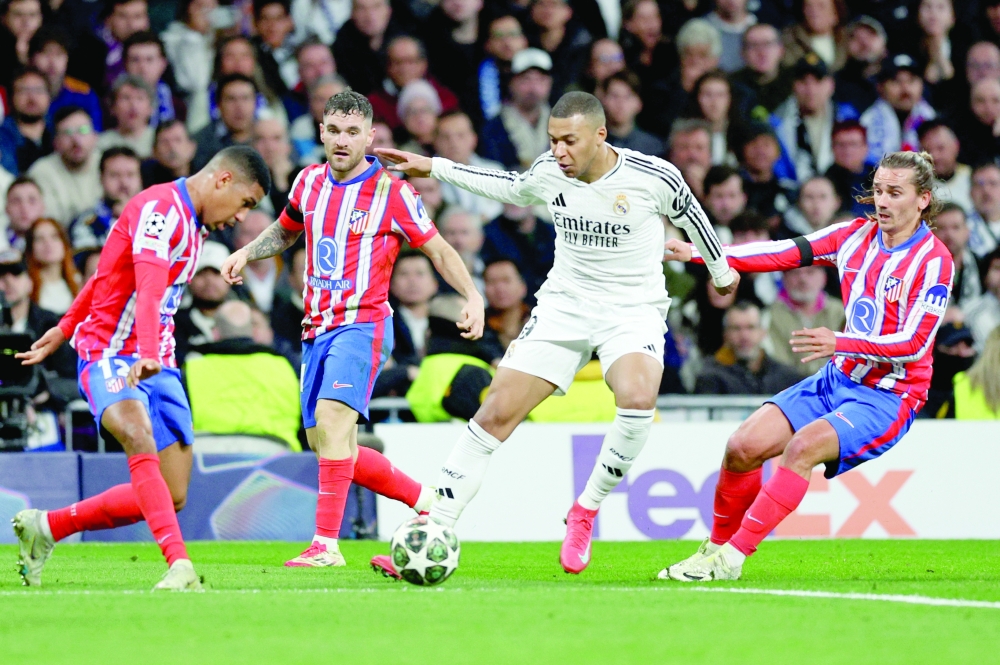 Real Madrid’s Kylian Mbappe in action with Atletico Madrid’s Samuel Lino and Antoine Griezmann.
