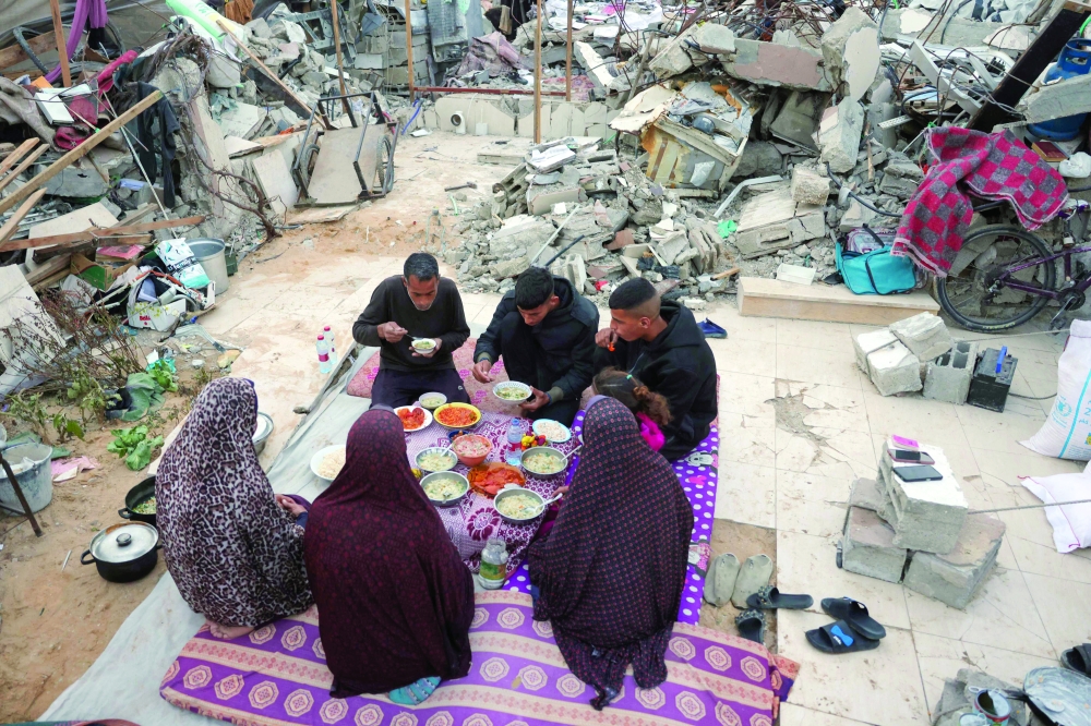 A doctor, head of the critical care department at the Beit Hanoun Hospital, has Iftar with his family outside their tent in Beit Lahia in the northern Gaza Strip on Wednesday. — AFP
