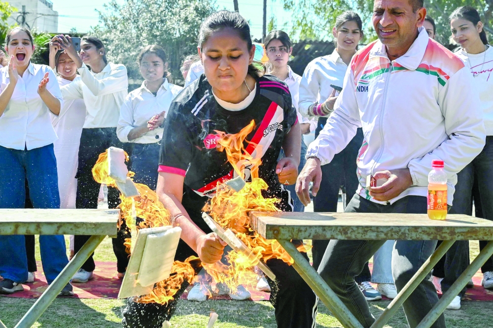 A student demonstrates her karate skills during an event ahead of International Women's Day at a college in Amritsar, India, on Thursday. - AFP
