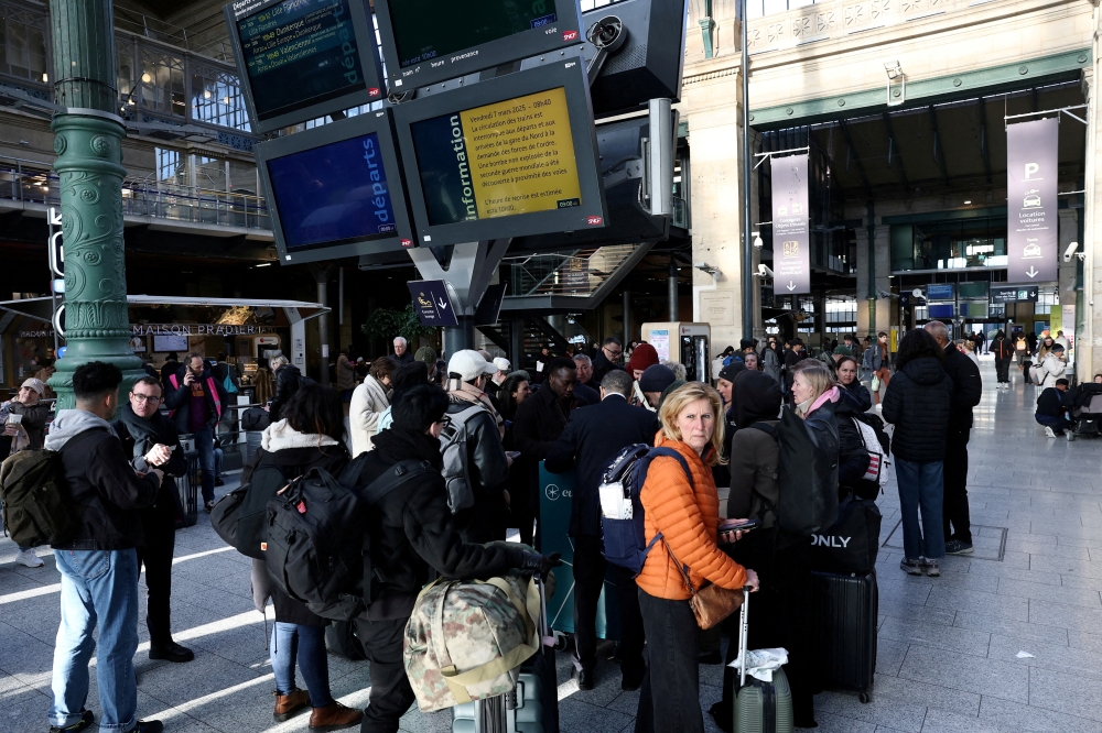 Passengers stand next to information screens at the departure hall as traffic has been disrupted at the Gare du Nord train station following the discovery of an unexploded bomb dating back to World War Two 2.5 km (1.55 miles) from the train statio