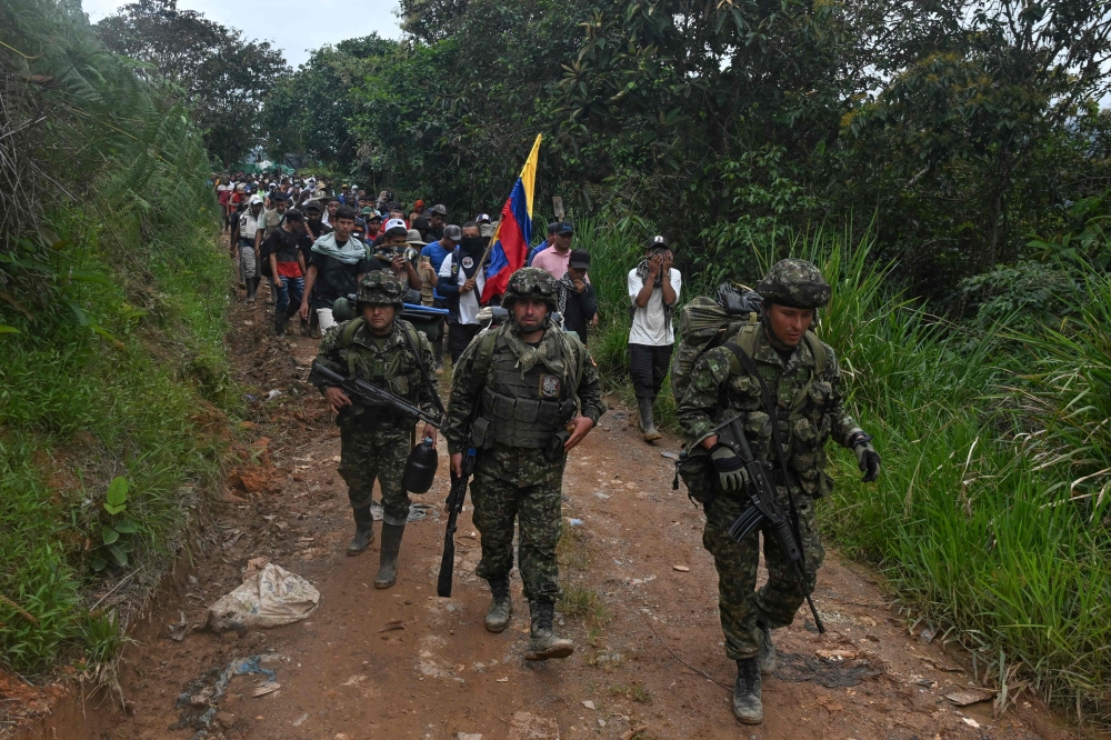 Soldiers leave after local communities force them out of the military base El Plateado, Colombia. — AFP