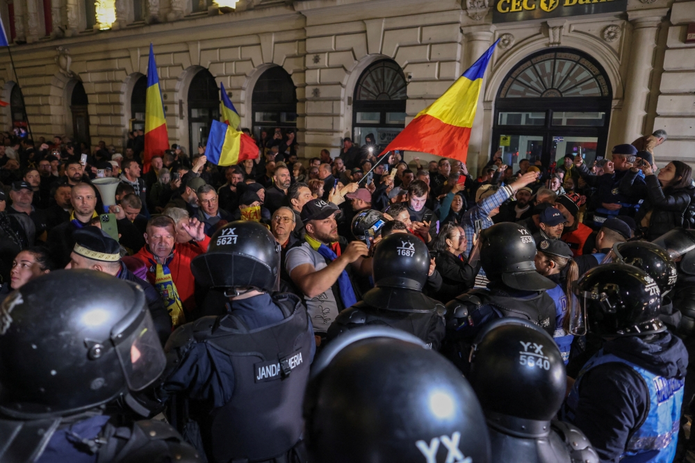 Supporters of far-right candidate Calin Georgescu confront riot police outside Romania's central electoral bureau, in Bucharest, Romania. — Reuters 