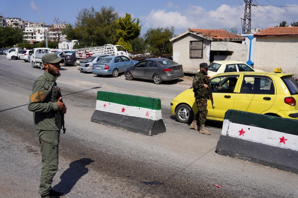 Members of Syrian security forces man a checkpoint at the entrance of Latakia. — Reuters