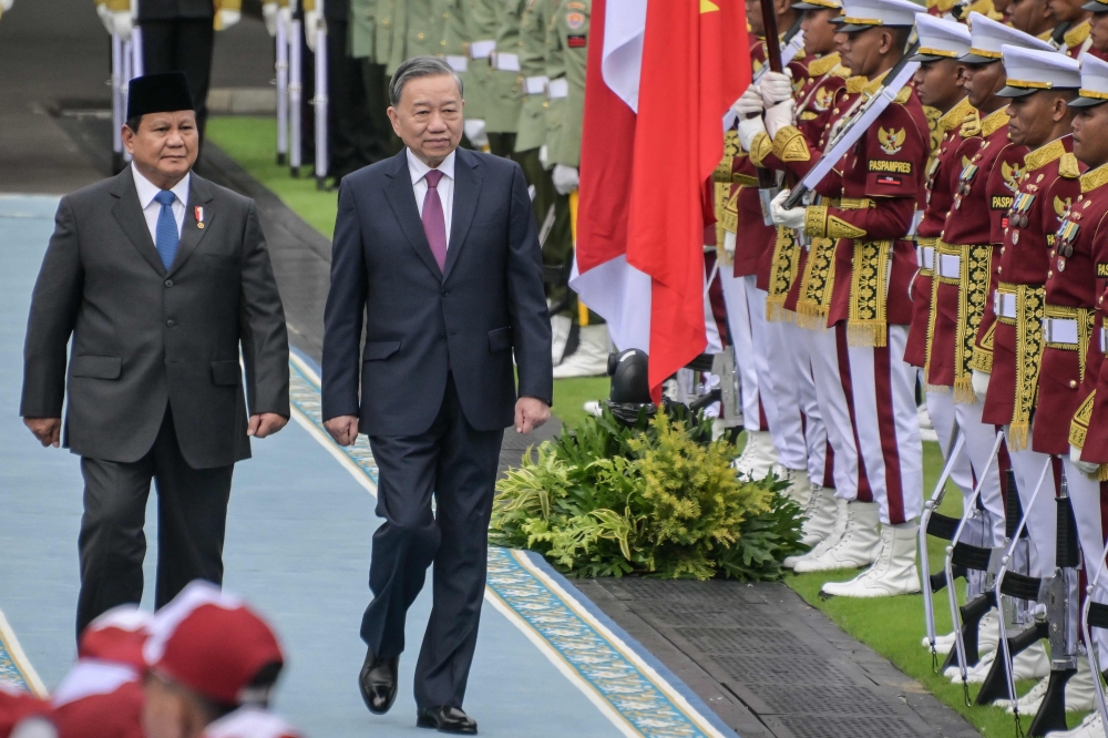 Indonesia's President Prabowo Subianto (L) and Vietnam's Communist Party General Secretary To Lam (C) inspect the Presidential guard of honour at the Presidential Palace in Jakarta. — AFP 