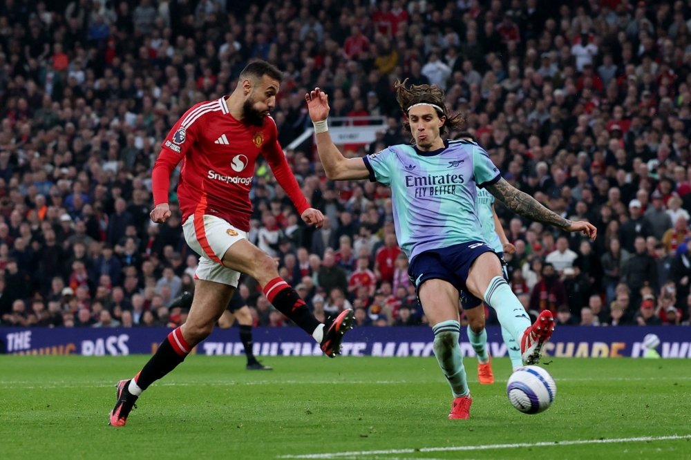Manchester United's Noussair Mazraoui in action with Arsenal's Riccardo Calafiori. — Reuters