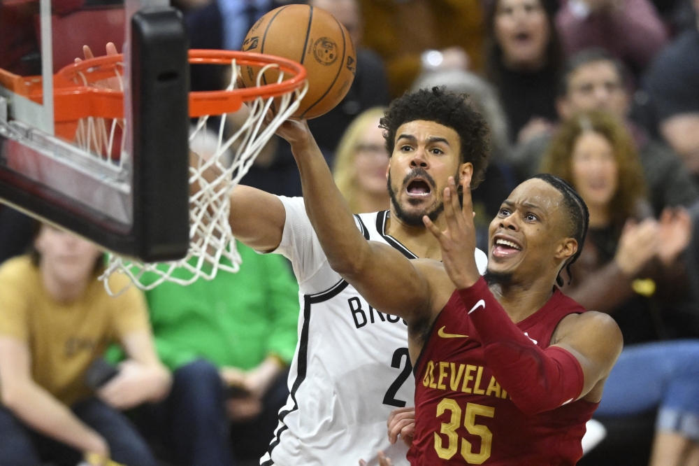 Mar 11, 2025; Cleveland, Ohio, USA; Cleveland Cavaliers forward Isaac Okoro (35) drives to the basket beside Brooklyn Nets forward Cameron Johnson (2) in the fourth quarter at Rocket Arena. Mandatory Credit: David Richard-Imagn Images
