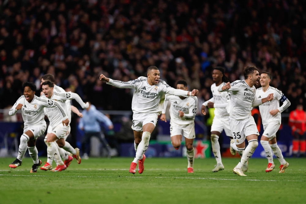 TOPSHOT - Real Madrid's French forward #09 Kylian Mbappe (C) celebrates with teammates after winning in a penalty shootout the UEFA Champions League Round of 16 second leg football match between Club Atletico de Madrid and Real Madrid CF at the Metropolitano stadium in Madrid on March 12, 2025. (Photo by OSCAR DEL POZO / AFP)

