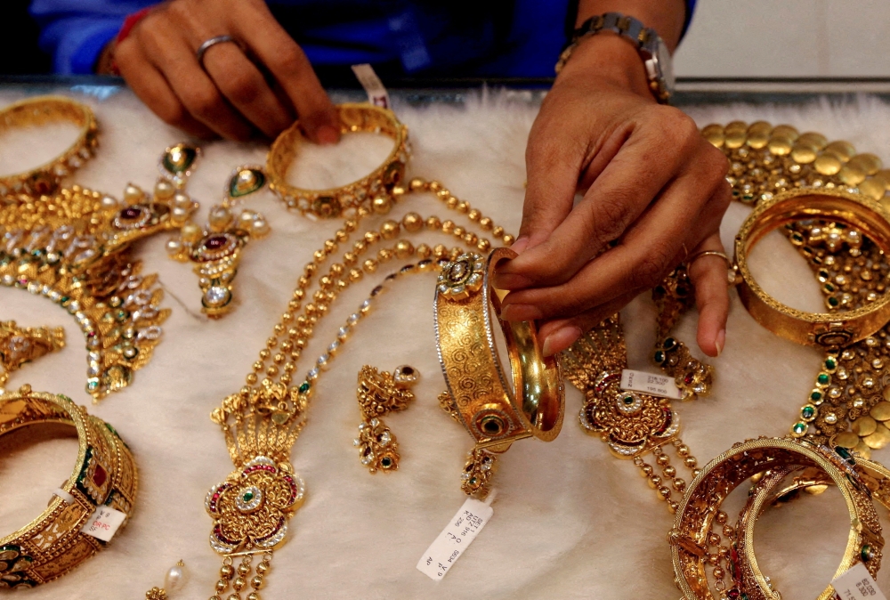 A woman looks at a gold bangle inside a jewellery showroom at a market in Mumbai. - Reuters File 