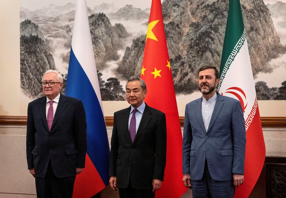 Chinese Foreign Minister Wag Yi, with Russian Deputy Foreign Minister Sergey Ryabkov, and Iranian Deputy Foreign Minister Kazeem Gharibabadi, before a meeting regarding the Iranian nuclear issue at Diaoyutai State Guest House in Beijing. - Reuters