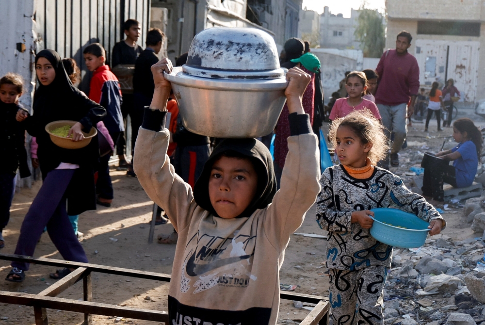 Palestinians receive food cooked by a charity kitchen, in Rafah