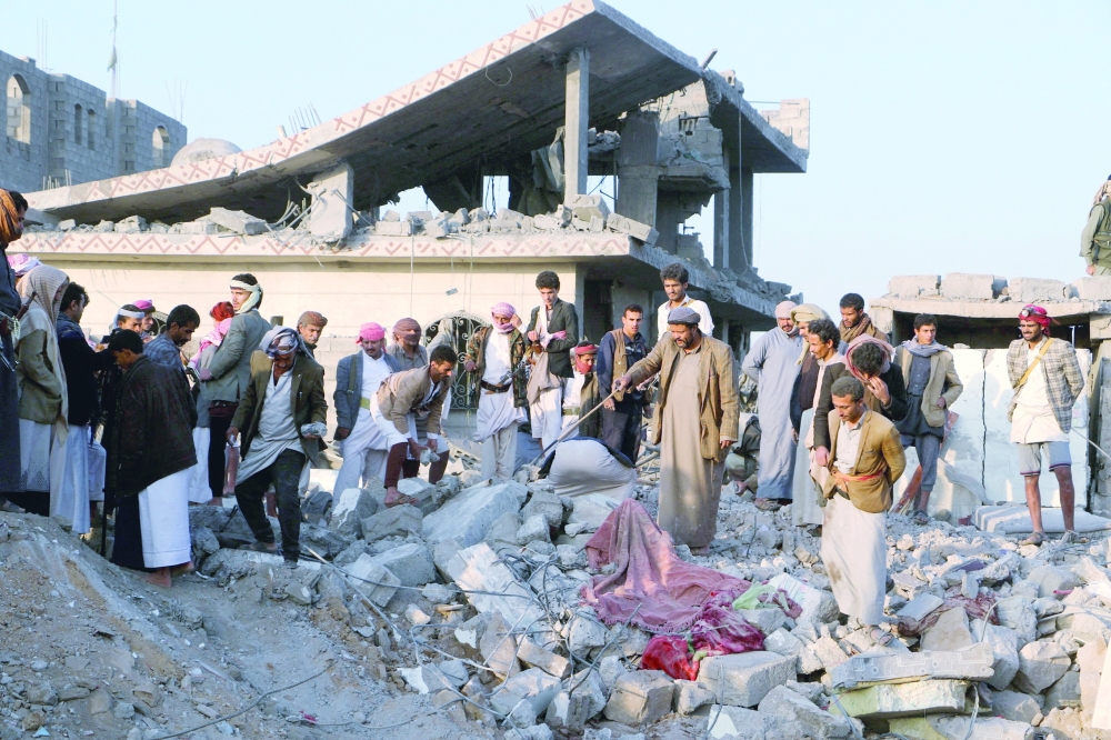 People gather on the rubble of a house hit by a US strike in Saada, Yemen. — Reuters
