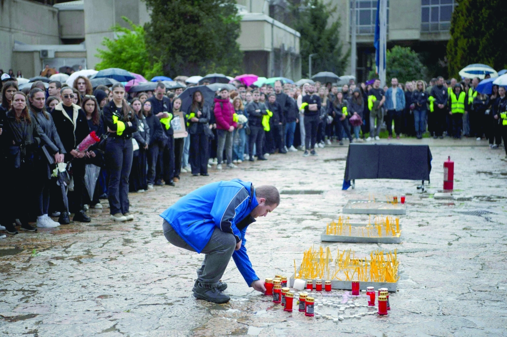 A student lights a candle at the University of Skopje during a memorial ceremony, in Skopje. — AFP