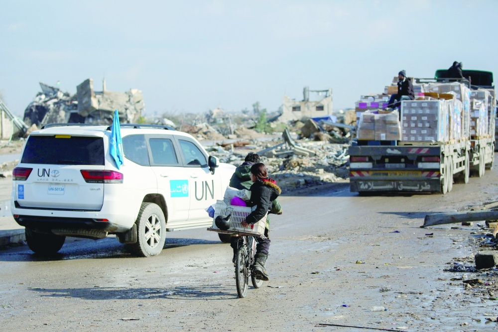 A UN vehicle escorts trucks carrying WHO (World Health Organization) aid