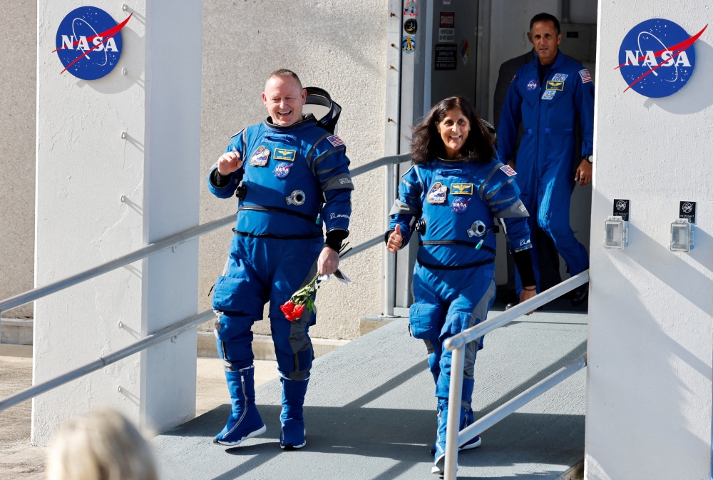 : NASA astronauts Butch Wilmore and Suni Williams walk at NASA's Kennedy Space Center