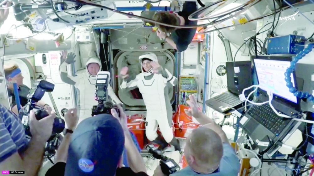 Butch Wilmore and Suni Williams wave at the hatch of a SpaceX Crew Dragon capsule. — Reuters