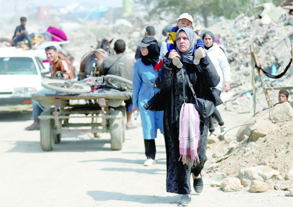 Palestinians made their way to flee their homes, after the Israeli army issued evacuation orders for a number of neighbourhoods on Tuesday. — Reuters