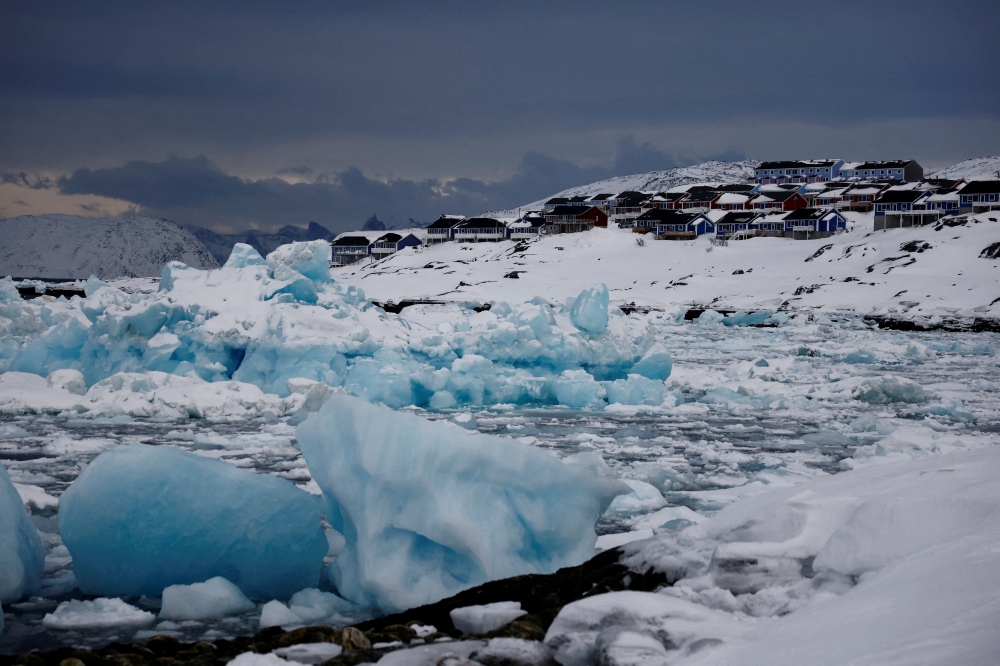 Ice floats in front of houses in Nuuk, Greenland, February 11, 2025.