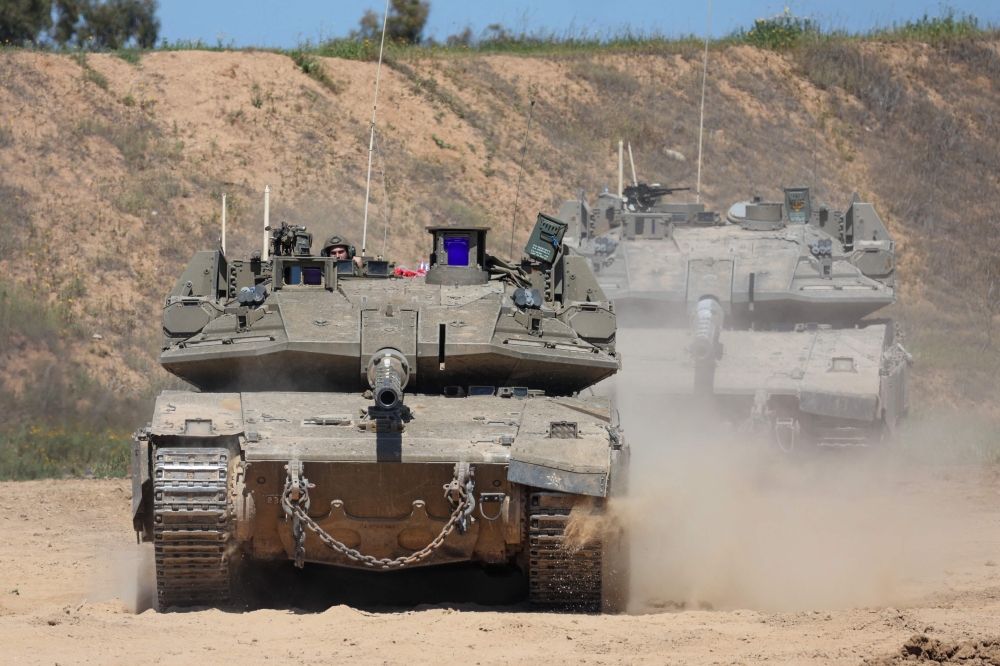 An Israeli soldier operates a tank at a position along Israel's southern border with the northern Gaza Strip on March 19, 2025. 