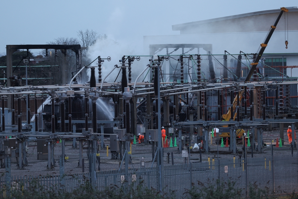 People work at an electrical substation after a fire there wiped out the power at Heathrow International Airport,