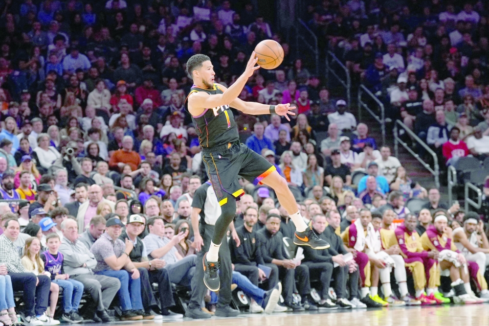 Phoenix Suns guard Devin Booker saves the ball from a back court violation against the Cleveland Cavaliers. —