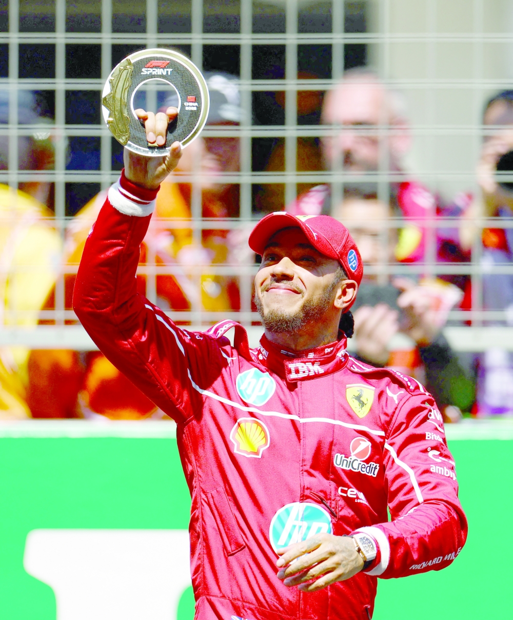 Ferrari's Lewis Hamilton poses with his trophy after winning the sprint race. — Reuters