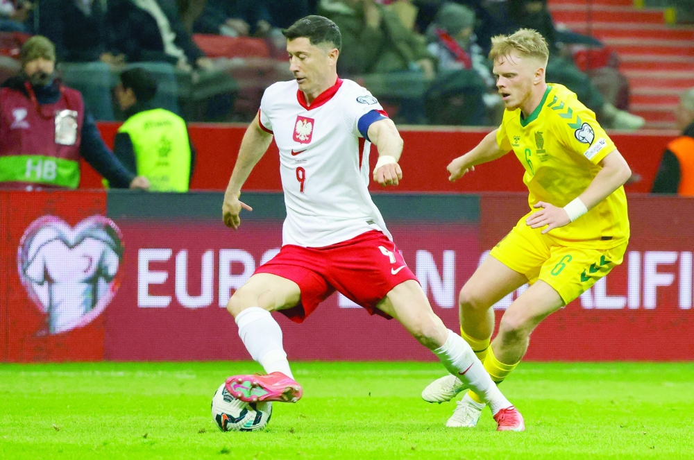 Robert Lewandowski (L) and Lithuania's midfielder Domantas Antanavicius vie for the ball. — AFP