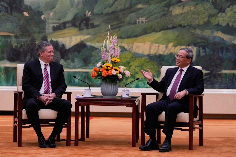 Chinese Premier Li Qiang (R) meets US Senator Steve Daines in the Fujian Room at the Great Hall of the People in Beijing. — AFP