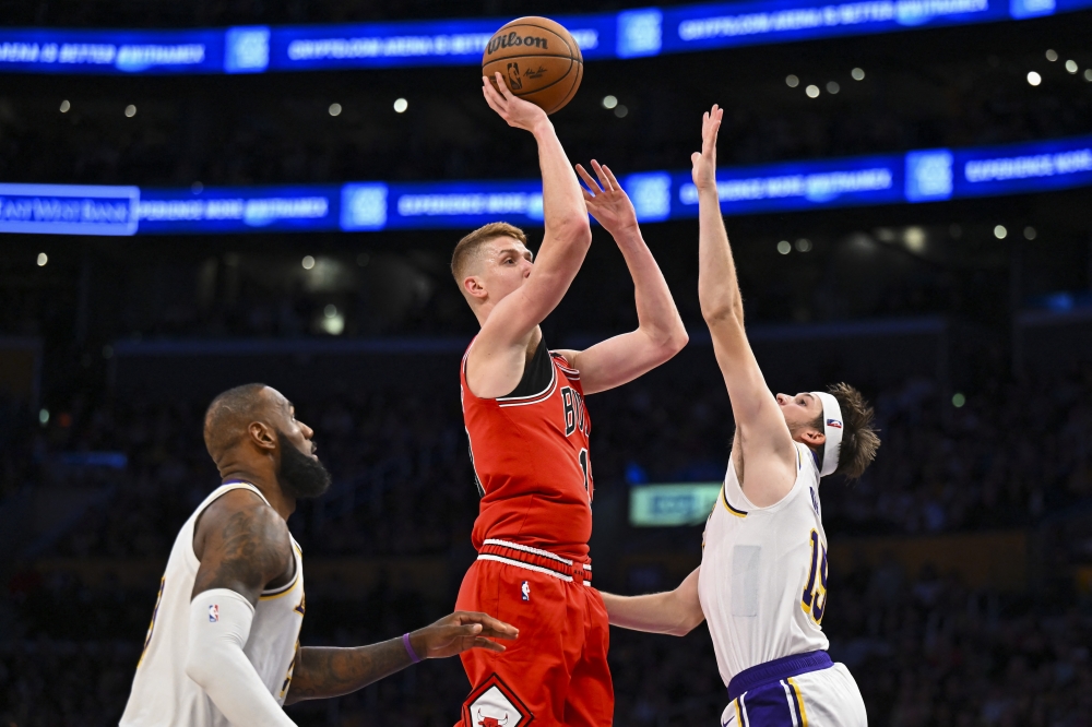 Chicago Bulls guard Kevin Huerter (13) shoots against Los Angeles Lakers guard Austin Reaves (15) and forward LeBron James (23) during the second half at Crypto.com Arena.  — Reuters