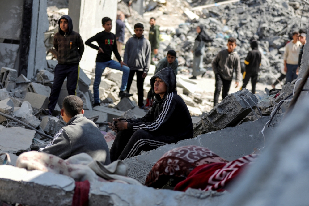 Palestinians gather at the site of an Israeli strike on a house, in Gaza City. — Reuters