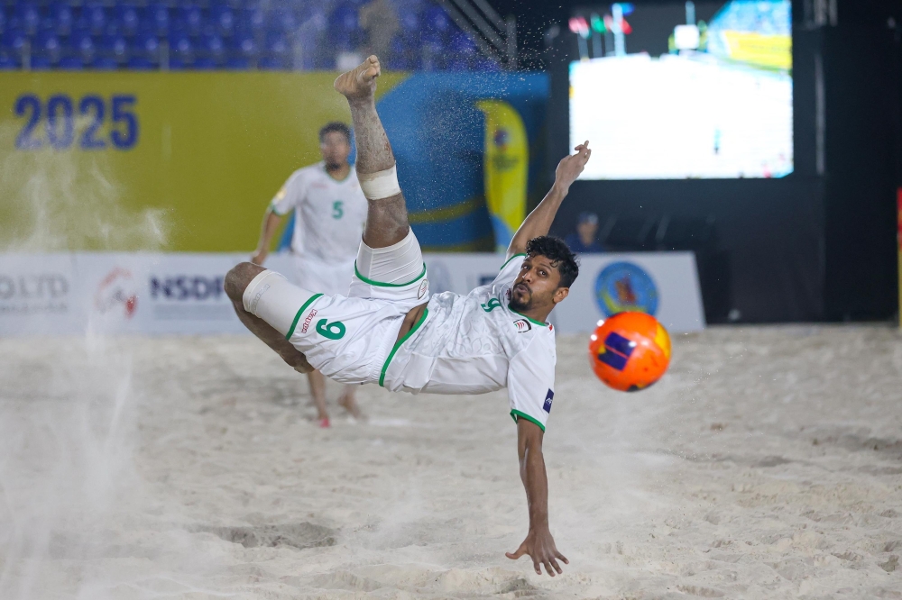 An Omani player tries an acrobatic kick.