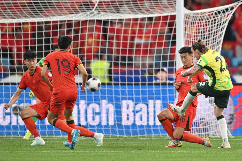 Australia's Jackson Irvine (R) scores a goal during the 2026 Fifa World Cup qualification football match between China and Australia. — AFP