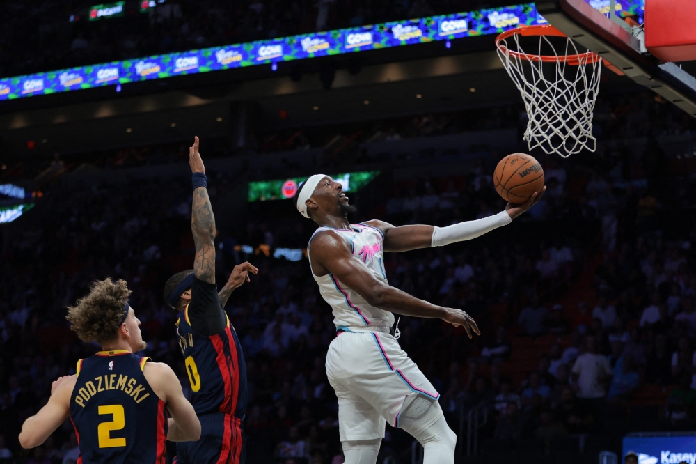Mar 25, 2025; Miami, Florida, USA; Miami Heat center Bam Adebayo (13) drives to the basket past Golden State Warriors guard Gary Payton II (0) during the third quarter at Kaseya Center. Mandatory Credit: Sam Navarro-Imagn Images
