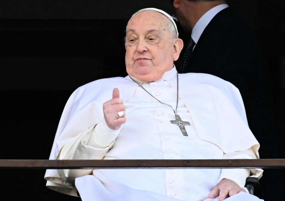 Pope Francis appears at a window of the Gemelli hospital before being discharged in Rome. - AFP