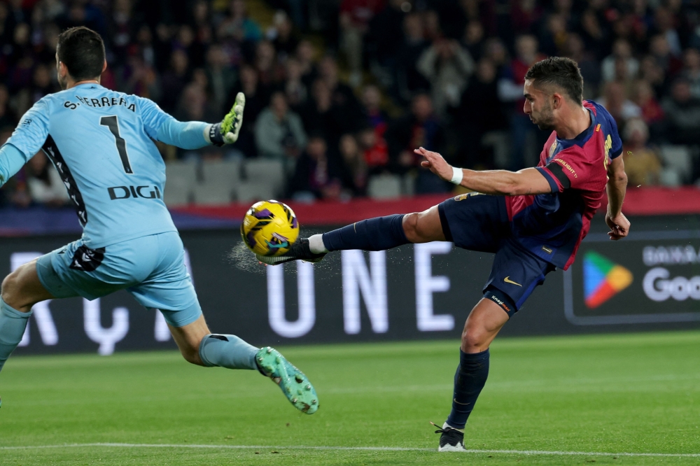 Barcelona's Spanish forward #07 Ferran Torres and Osasuna's Spanish goalkeeper #01 Sergio Herrera Piron fight for the ball during the Spanish league football match between FC Barcelona and CA Osasuna at Estadi Olimpic Lluis Companys in Barcelona on March 27, 2025. (Photo by LLUIS GENE / AFP)

