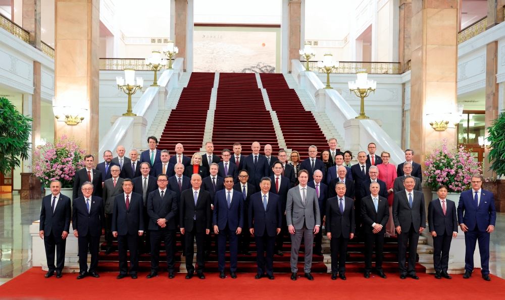 Chinese President Xi Jinping and representatives of the international business community pose for photo at the Great Hall of the People in Beijing. - Reuters  