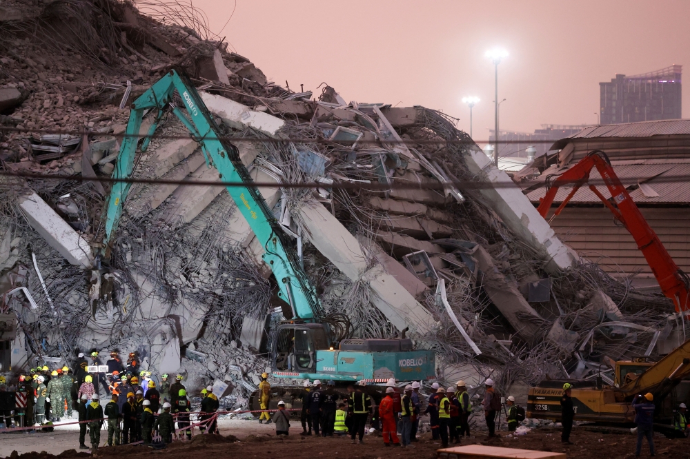Rescue personnel work at the site of a building that collapsed, following a strong earthquake, in Bangkok. — Reuters