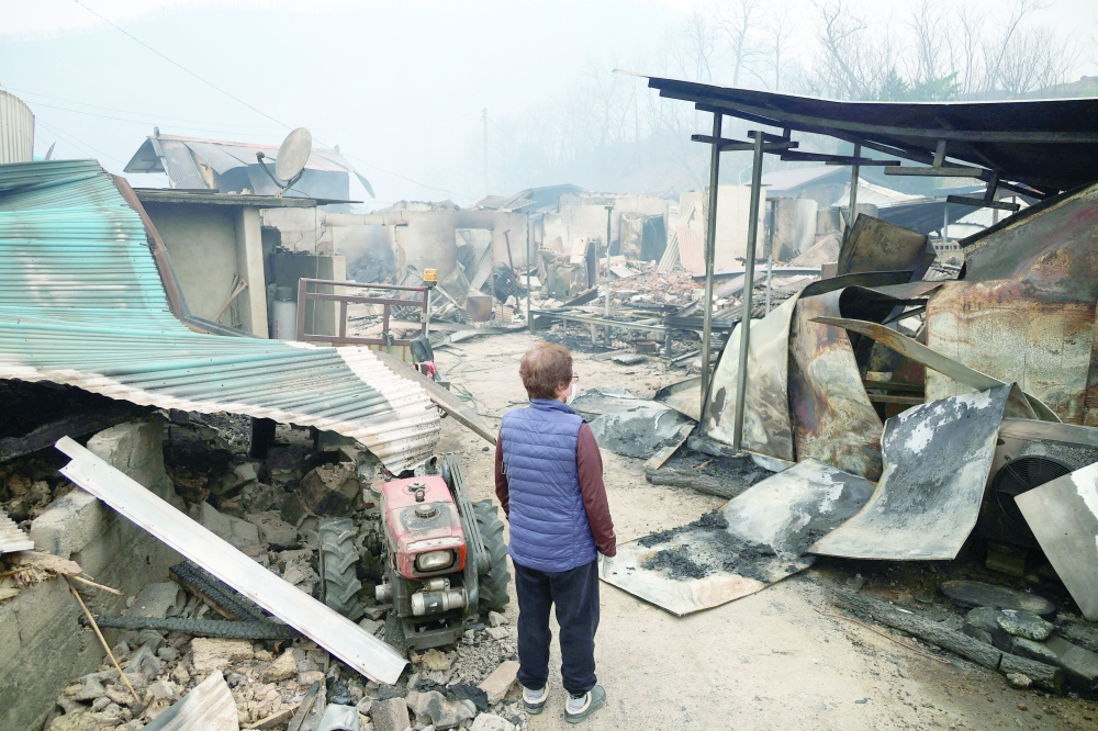 Kun Yeong-nam, 72, looks around her burnt house