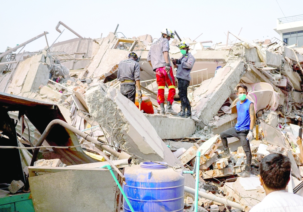 Rescuers work at the site of a building that collapsed, in the aftermath of a strong earthquake, in Mandalay, Myanmar, on Sunday. - Reuters