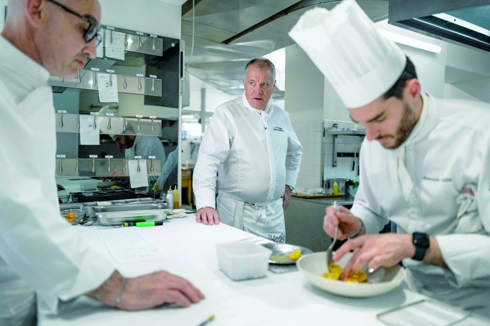 French Chef Patrick Henriroux watches a cook work in the kitchen of 'La Pyramide' restaurant in Vienne. — AFP