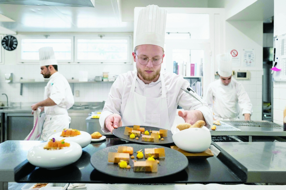 Cooks work in the kitchen of 'La Pyramide' restaurant in Vienne. — AFP