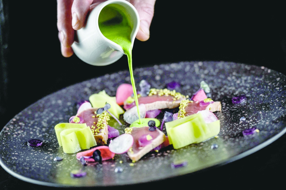 A cook prepares a dish at 'La Pyramide' restaurant in Vienne. — AFP