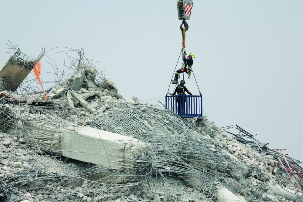 Rescue personnel work at the site of a building that collapsed, following a strong earthquake, in Bangkok on Monday. — Reuters