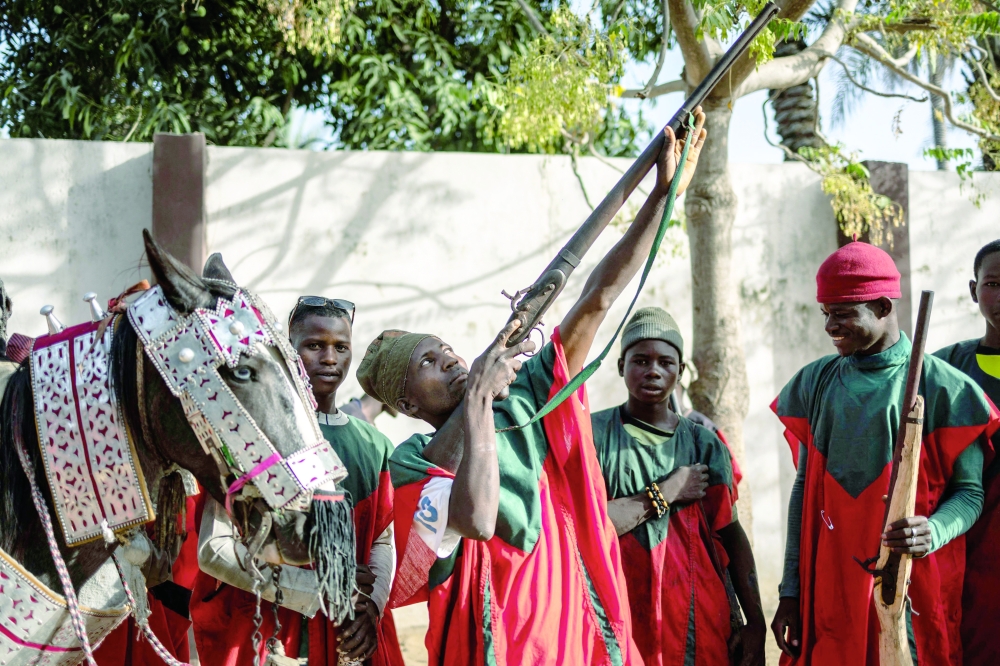 A royal hunter poses with his gun at the residency of the Emir of Dutse. — AFP