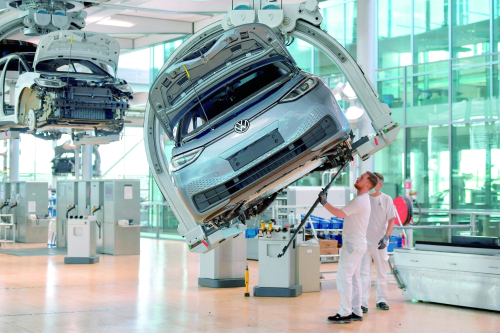 Technicians work on the assembly line of German carmaker Volkswagen in Dresden, Germany. — Reuters