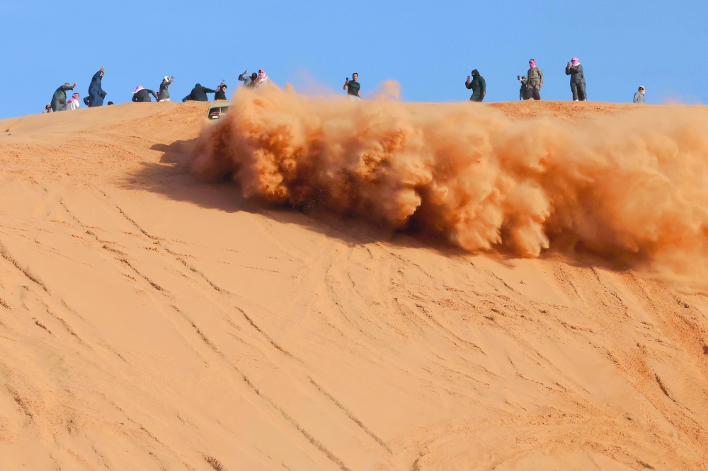 A Saudi driver drives his car up a dune in the Quseiba area, in the Az Zulfi desert.