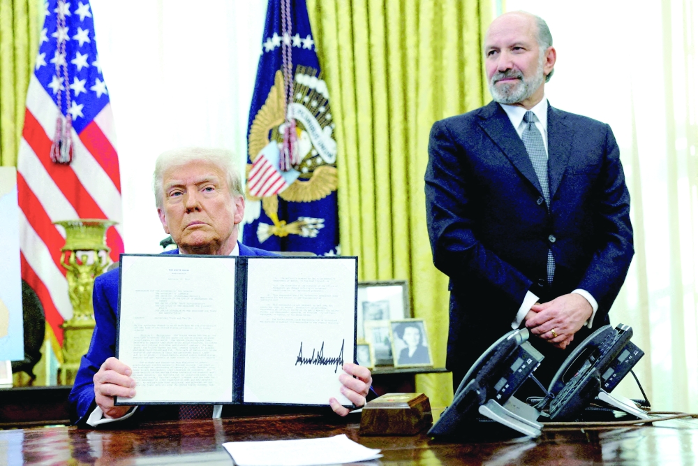 US President Donald Trump holds an executive order about tariffs increase, flanked by US Commerce Secretary Howard Lutnick, in the Oval Office of the White House in Washington. — Reuters